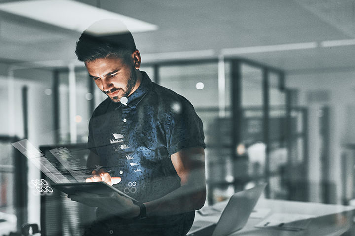 state-of-customer-experience Jonge zakenman die op zijn tablet werkt met grafieken en digitale informatie die van tablet uitzenden
