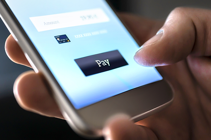 photo de proche vue de quelqu'un anonyme qui complete un paiement sur leur portable