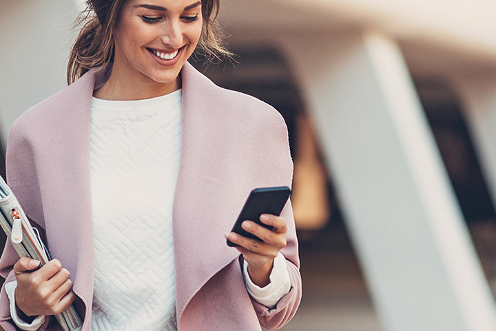woman looking at her mobile phone woman looking at her mobile phone