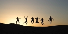 groupe de personnes sautant en l’air avec le coucher du soleil