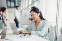 femme qui est en face de son ordinateur, elle travaille dans un bureau