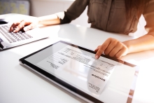 Close-up Of A Businesswoman's Hand Working With Invoice On Digital Tablet