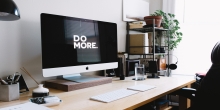 Desktop computer with black and white screen text saying Do More.