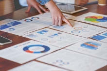 Finger pointing to charts and graphs