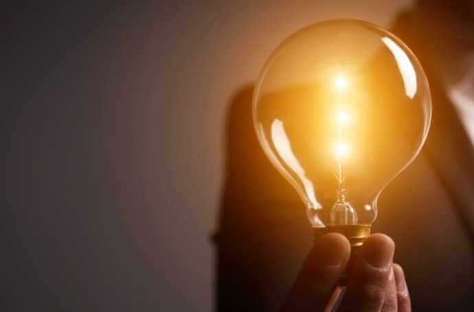 Person's hand holding a lighting bulb Person's hand holding a lighting bulb