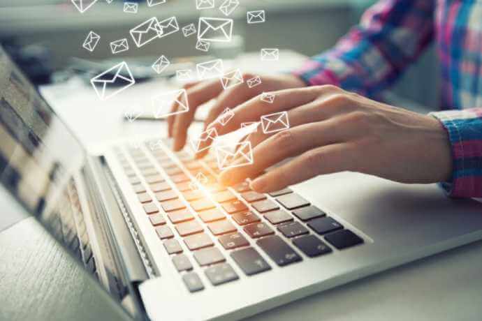 Typing on a laptop and mail icons emerging Typing on a laptop and mail icons emerging