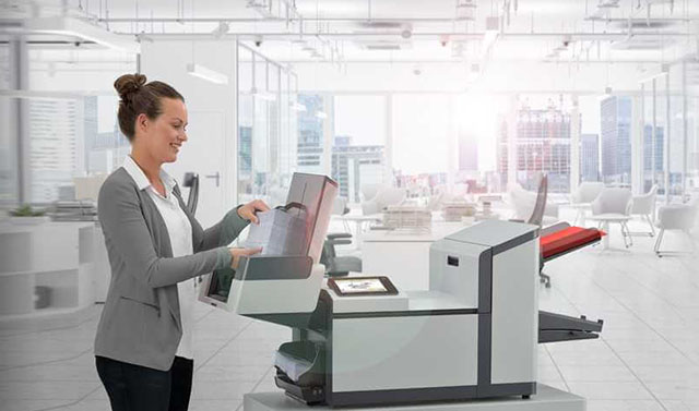 a woman using a folder inserter