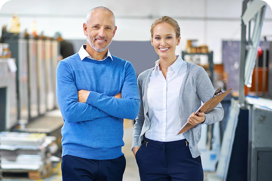 a man and a woman in an office smiling at camera a man and a woman in an office smiling at camera